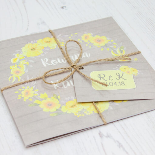 Close up of Folded Buttercup Flutter Wedding Invitations with String & Tag