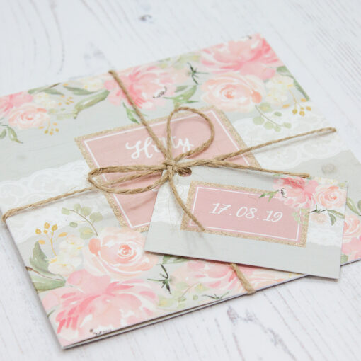 Close up of Folded Enchanted Garden Wedding Invitations with String & Tag
