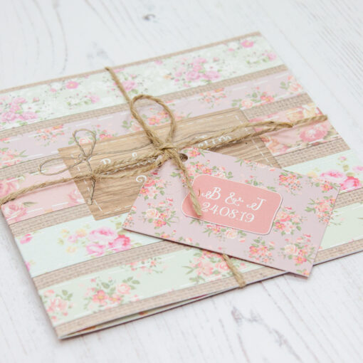 Close up of Folded Floral Furrows Wedding Invitations with String & Tag