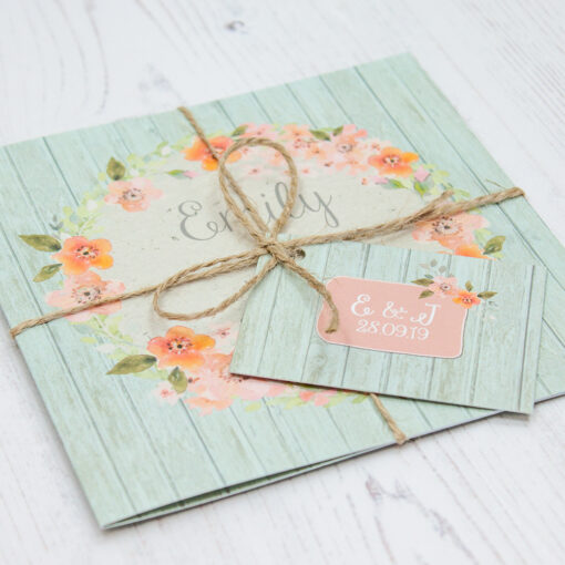 Close up of Folded Prairie Peach Wedding Invitations with String & Tag